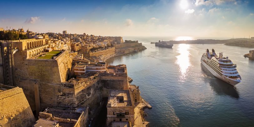 Luxury cruise ship sailing close to shore - expert cruise planning and custom vacation packages