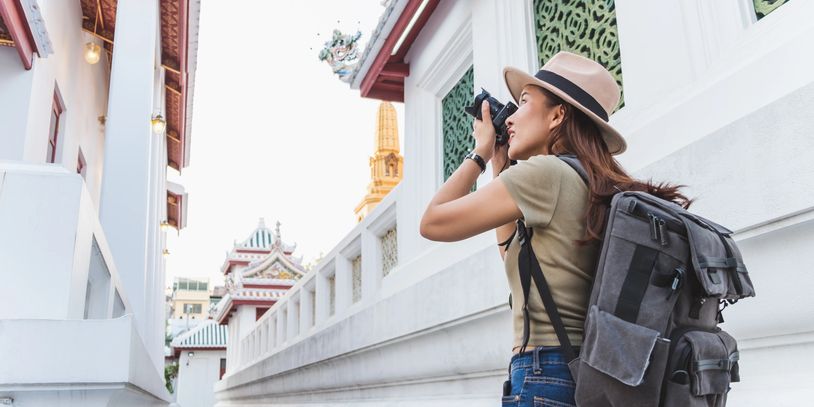 Solo traveler with a backpack snapping a photo - expert solo trip planner services