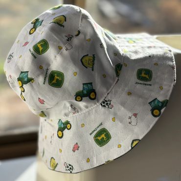 White bucket hat with John Deere and farm animal prints.