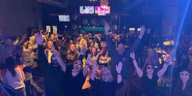 Excited crowd enjoying a lively night at a club or bar.