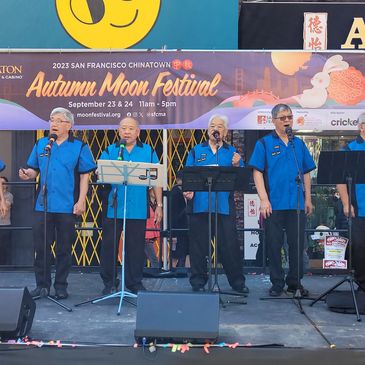 Six men in blue shirts performing on stage at the San Francisco Chinatown Autumn Moon Festival.