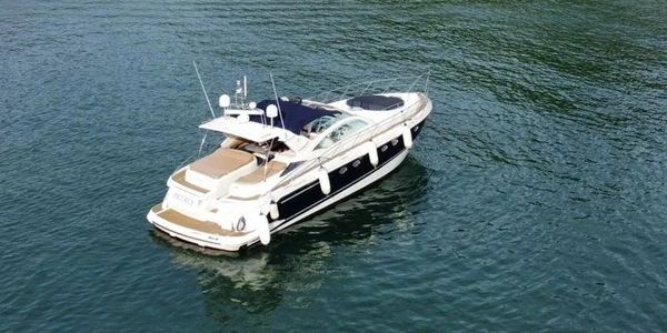 Luxury motor yacht Petrus anchored on calm water, featuring a sleek design and dark canopy