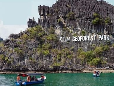 Local wooden boats anchoring at Kilim Geoforest Park signage