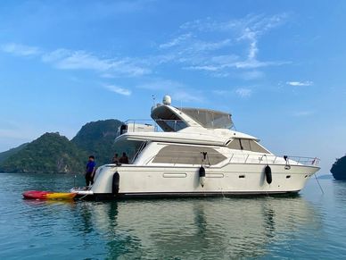 Seawolff Luxury Motor Yacht on calm waters with island backdrop and people onboard