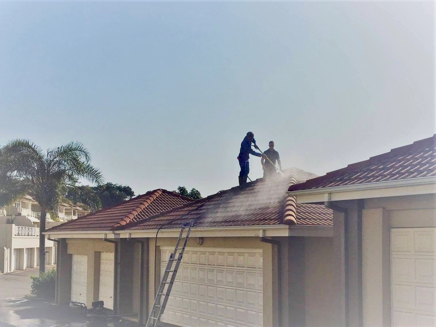 Coast Pro technician soft washing a tiled roof on the Sunshine Coast