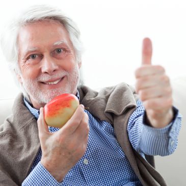 A very happy patient with secure dentures after having dental implants placed at Loughlin Dental.