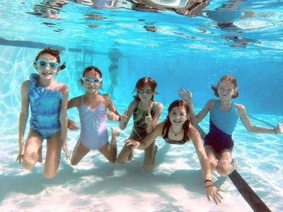Kids swimming underwater in a pool