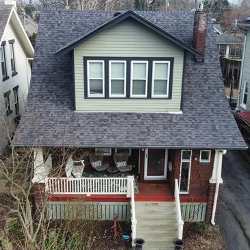 A two-story house with a front porch and swing seats.