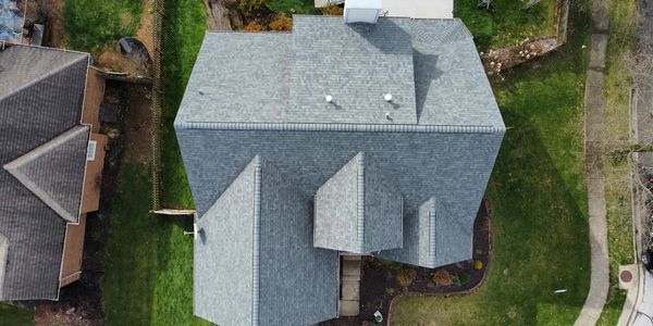 Aerial view of a residential house and its surroundings.