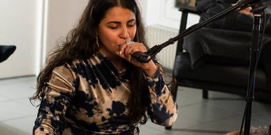 Woman singing into a microphone.
