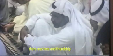 Men in traditional Middle Eastern attire sitting closely together, sharing a moment of friendship.