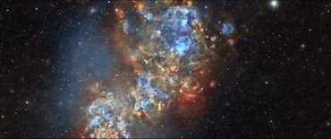 A vibrant, colorful nebula with blue, orange, and red hues in deep space.