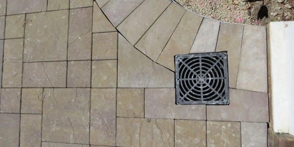 Outdoor tiled floor with drainage grate.
