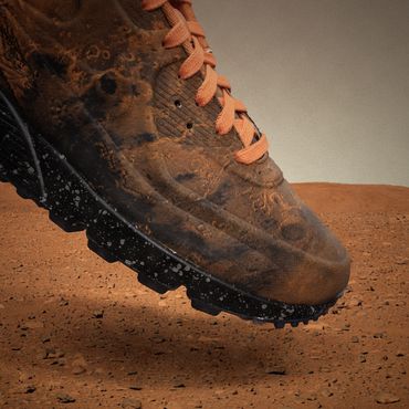 Close-up image composite of planetary themed sneakers stepping onto the surface of the planet Mars