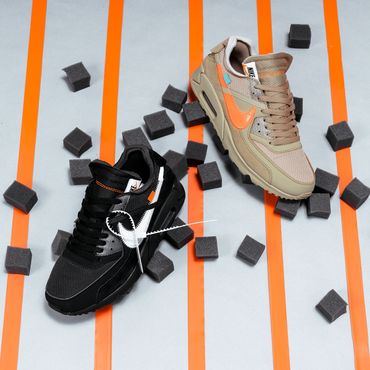 Shoes playfully mingle with black foam cubes in front of a complimentary striped background