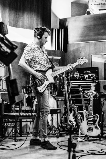 Nick playing his bass guitar in the studio.