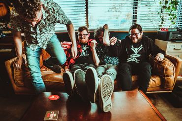 Tiny City is trying to get comfortable on a couch in the recording studio.