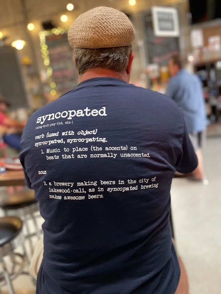 Back of a Syncopated shirt printed with the definition of syncopated