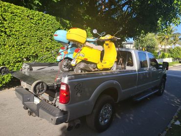 Towing two Vespas in Palm Beach on a flatbed to get serviced in West Palm Beach.