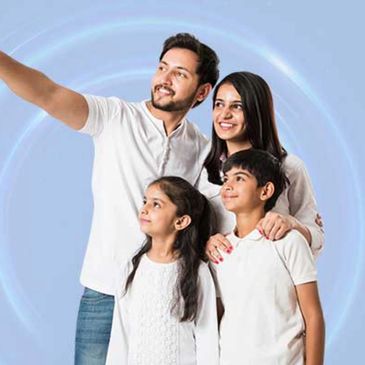 Life insurance. Family of four, a father, a mother and two children smiling at the horizon.