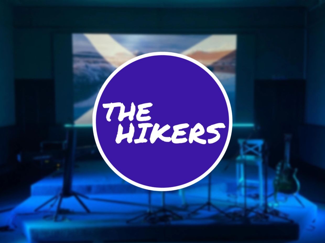 Stage setup for The Hikers band with a Scottish flag backdrop and instruments.