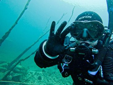 Scuba diver underwater making an OK hand sign.