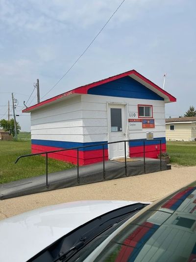 Small building painted white, blue, and red with a wheelchair ramp.