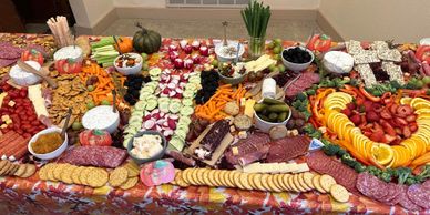 A colorful charcuterie spread with meats, cheeses, fruits, and crackers.