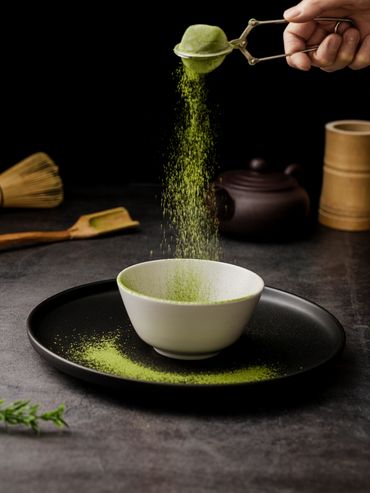 taza de te siendo espolvoreada de matcha