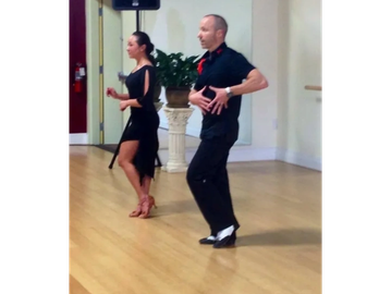 A man and woman dancing indoors.