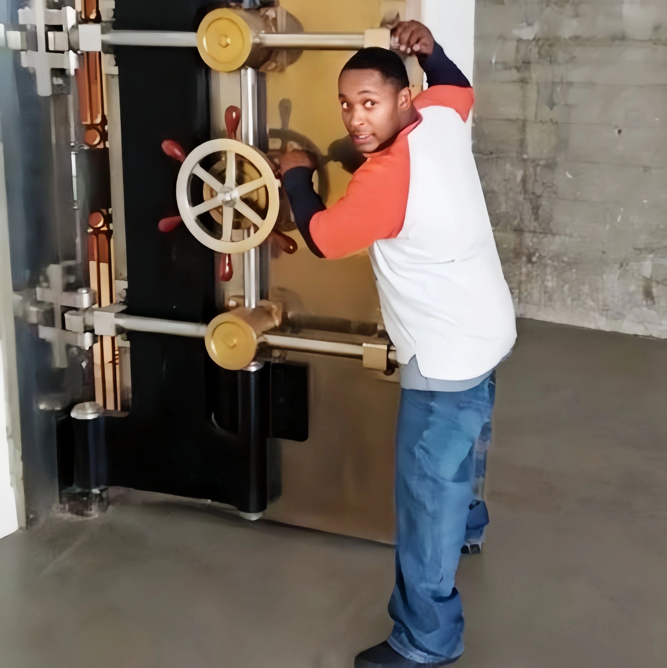 Man opening a large, secure vault door with a wheel handle.