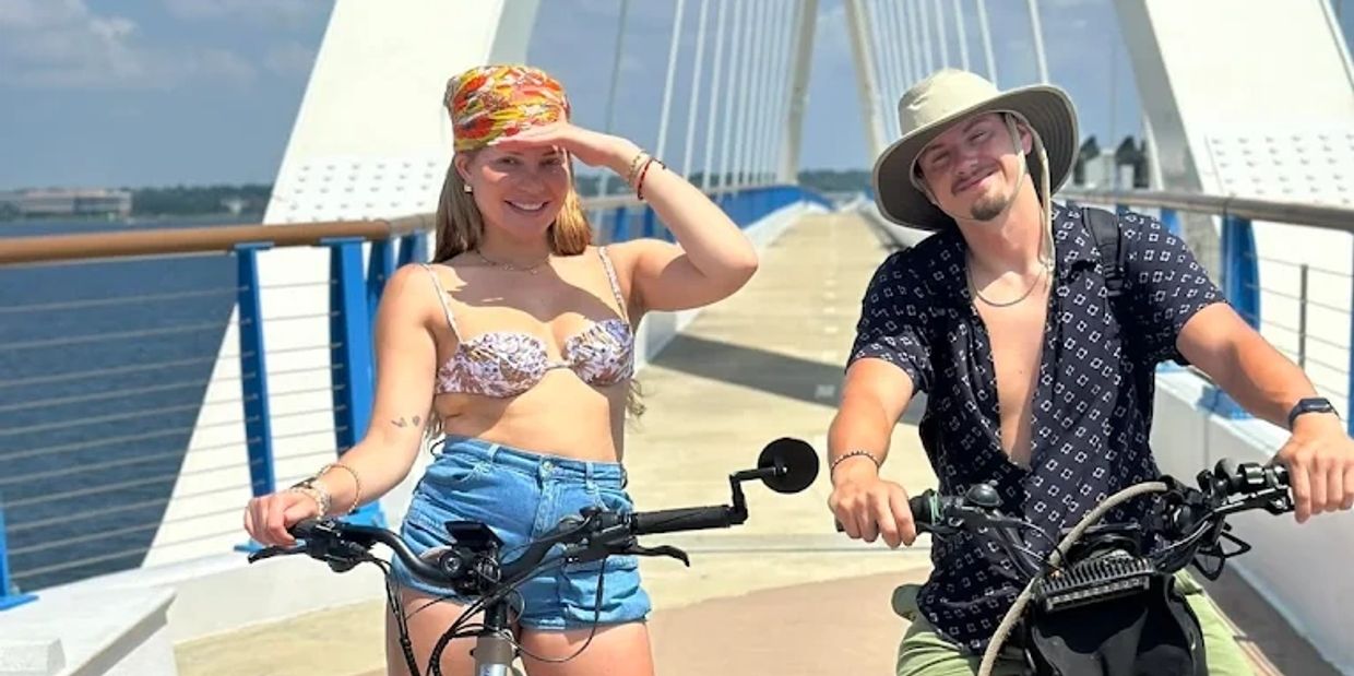 Two people enjoying E-Bike Rentals in Pensacola on the Bay Bridge.