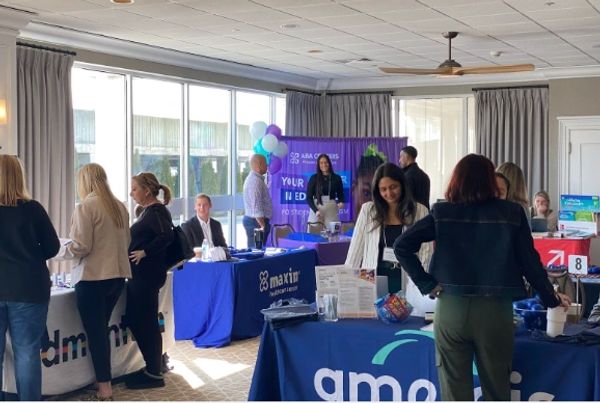 Networking event with booths and attendees exchanging information.