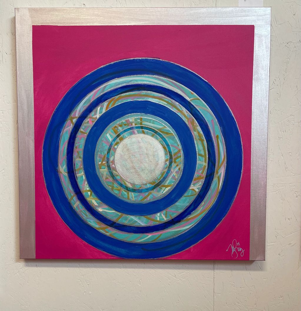Abstract painting with concentric blue circles on a pink and silver background.
