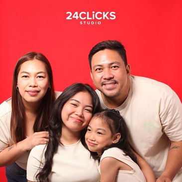Happy family posing together in front of a red background.