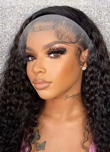 Woman with long curly hair and detailed makeup posing against a glittery backdrop.