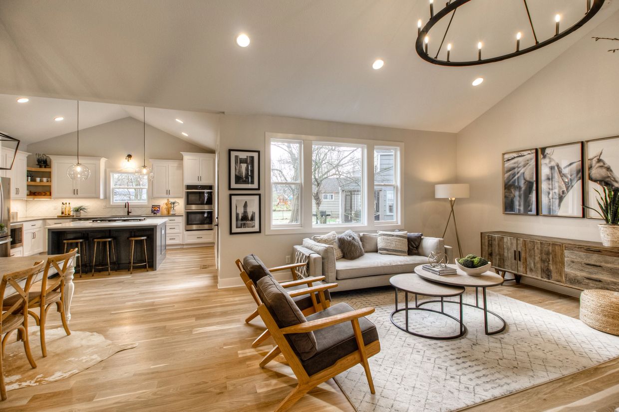 Open-concept Charleston living room and kitchen remodel with vaulted ceilings, white cabinetry.