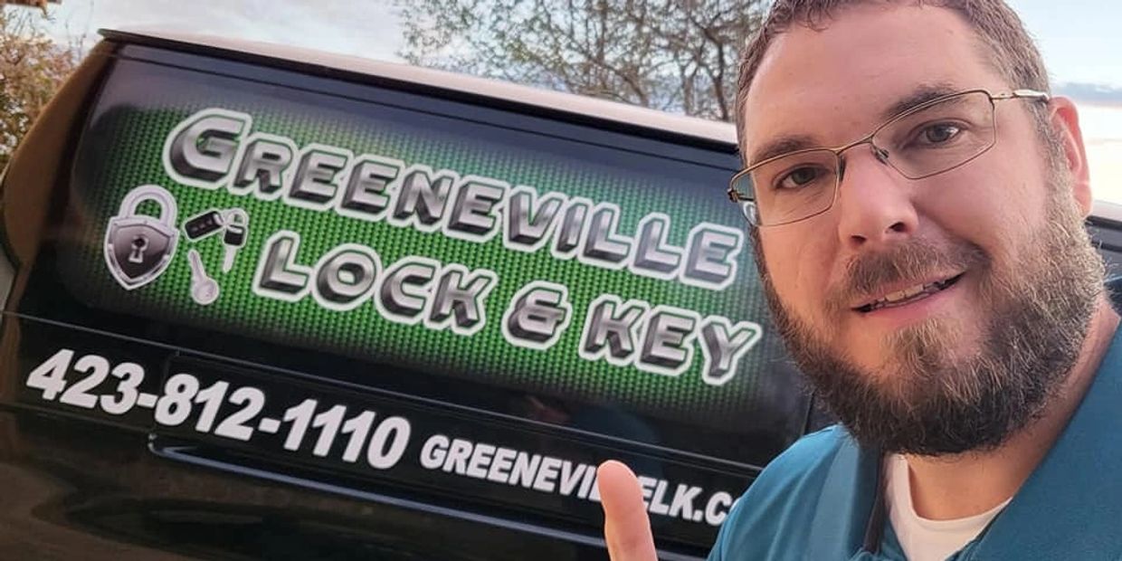 Man pointing to a Greeneville Lock & Key service van with contact details.