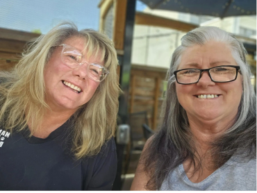 Two smiling women wearing glasses.