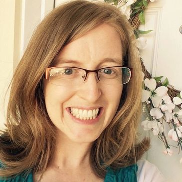 Smiling woman with glasses and light brown hair.