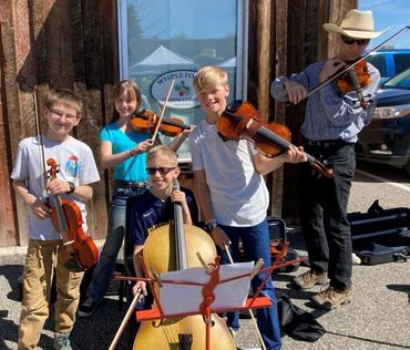 Joe Jewett with a group of fiddlers playing violin, viola, and cello