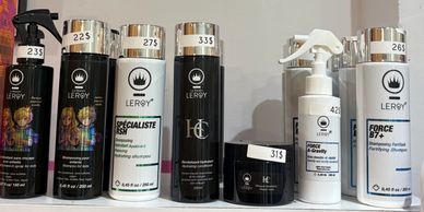 Une rangée de produits capillaires Leroy avec des étiquettes de prix.
