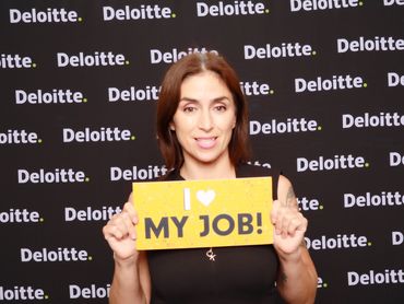 Deloitte employee with 'I Love My Job' sign at FlashFolio Booth corporate event in OC.