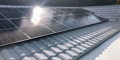 Expert Installation of solar panel energy on angled white stone metal roof
