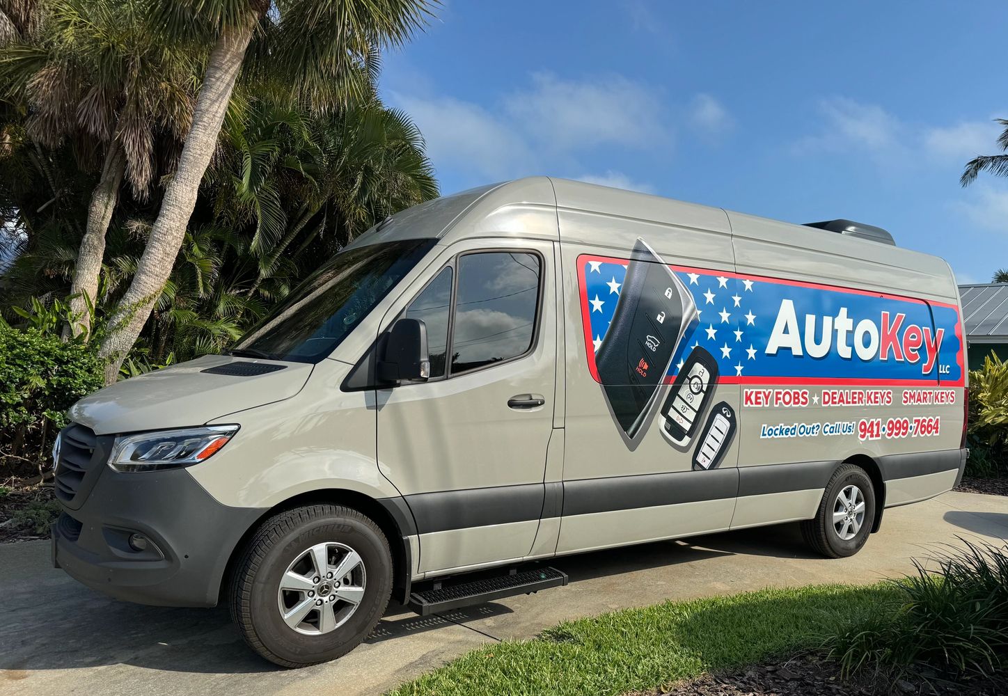 A beige van with AutoKey advertising and car key images on the side.