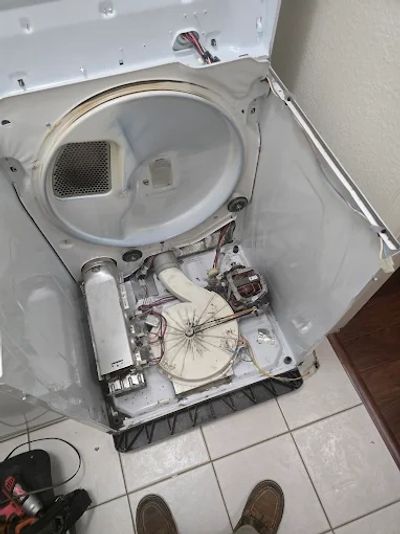 Open dryer with missing drum and exposed internal components.