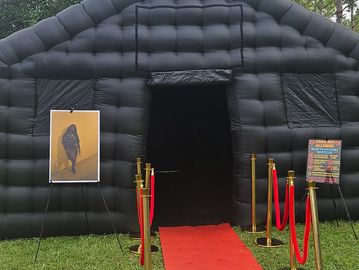 Inflatable black structure with red carpet and velvet ropes.