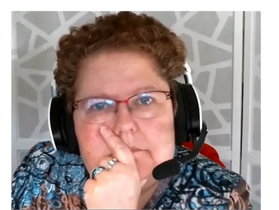 Katherine with headset and hand over her mouth, deep in thought.