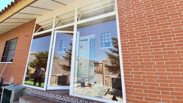 Cierre en aluminio blanco con puerta abatible, fijos y ventanas oscilo batientes.
