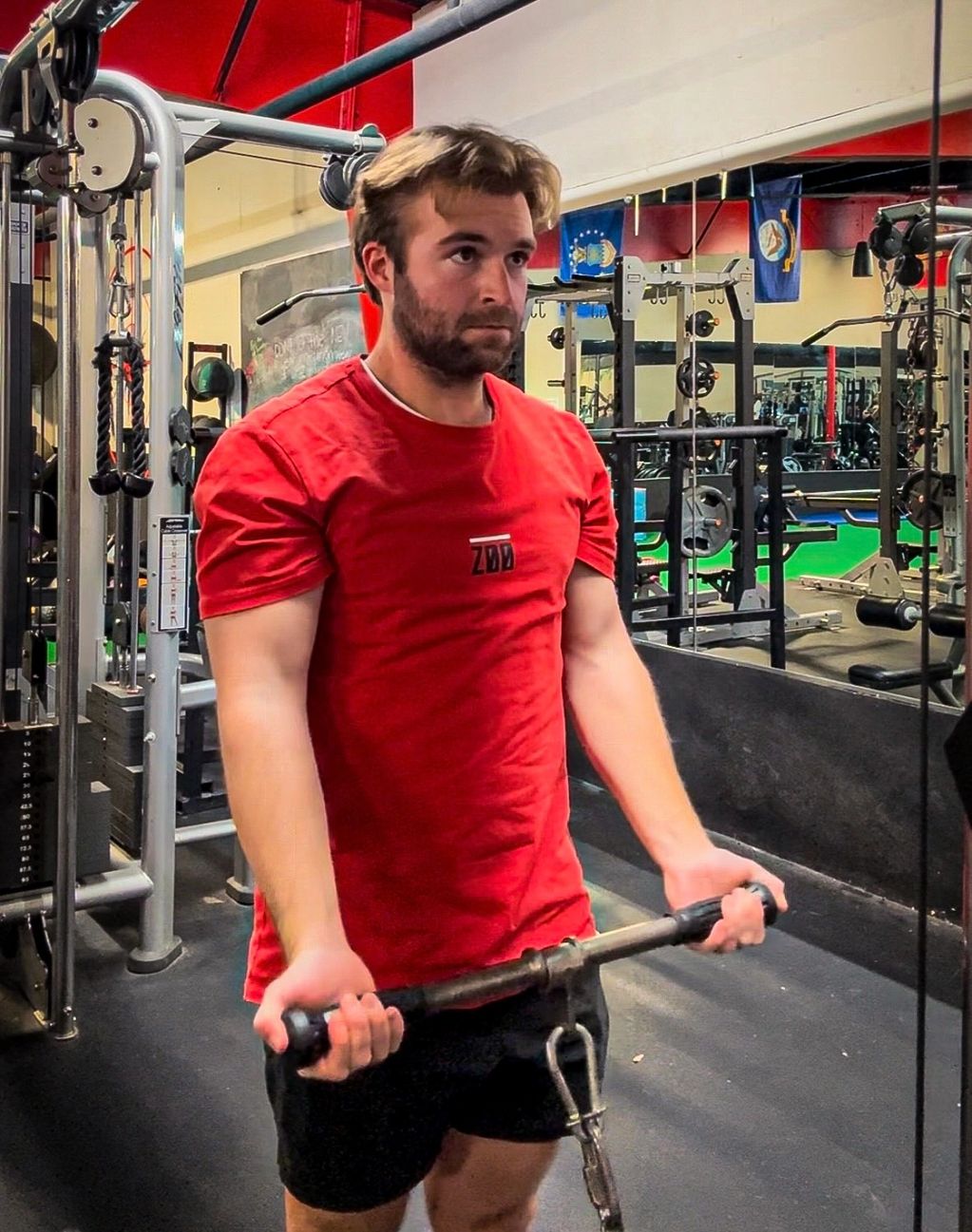 Man working out in a gym with a cable machine.